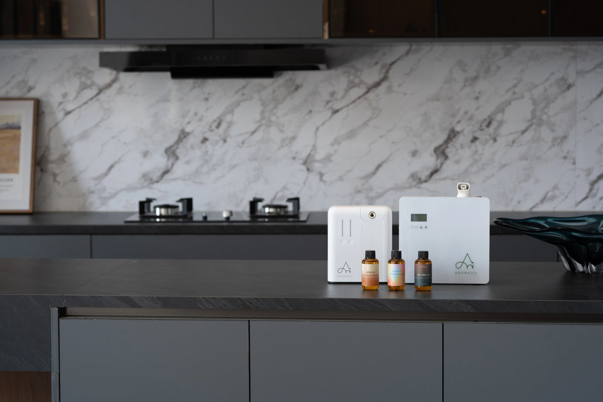 Aromadd large room diffusers with fragrance oil bottles on a modern kitchen counter